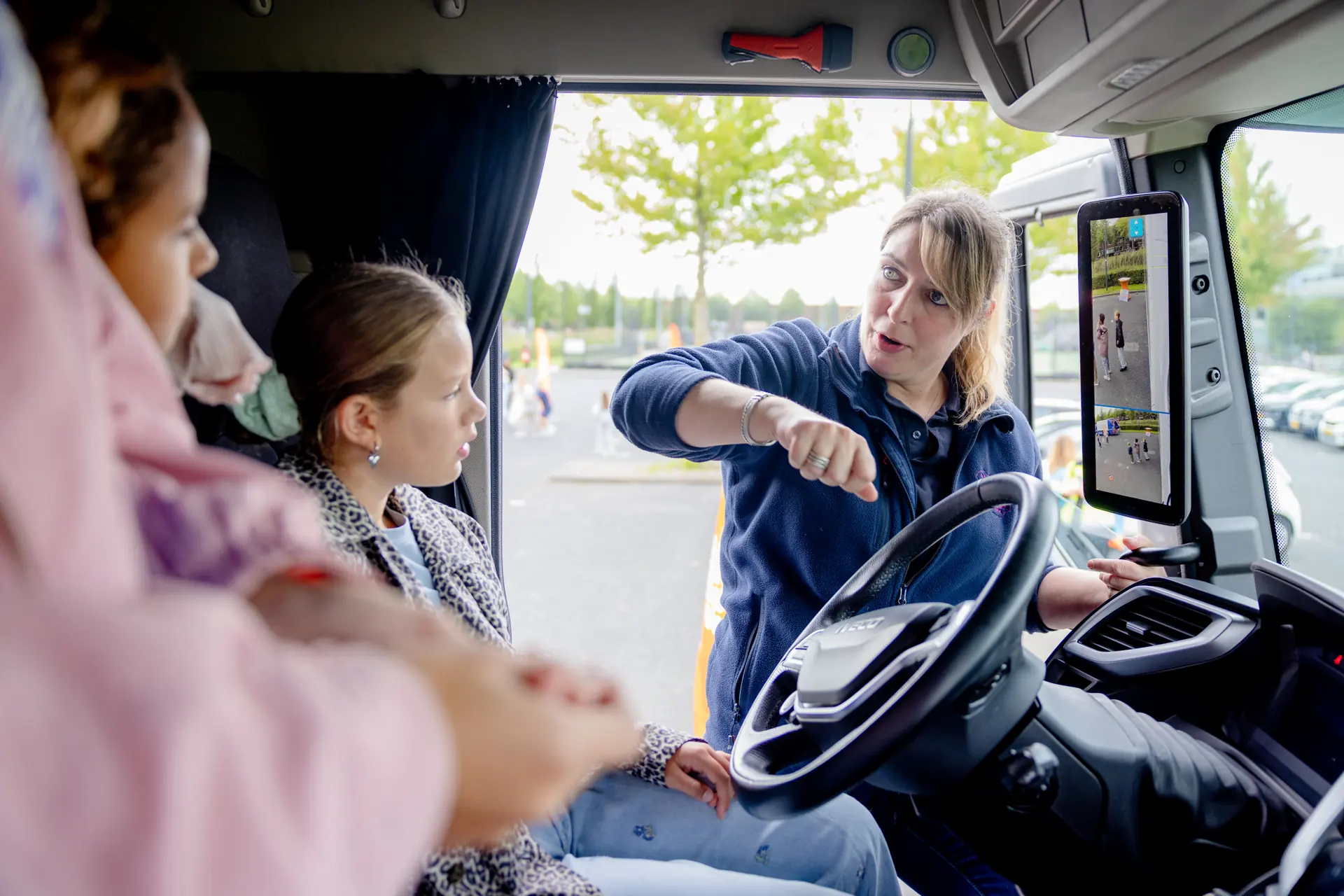 Des enfants découvrent, avec un accompagnement, la vue depuis la cabine d’un camion à Het Tangram.